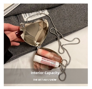 Detailed interior of silver heart-shaped metal clutch bag with silver chain