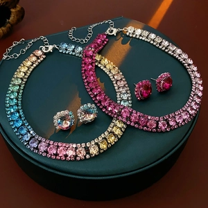 Detailed view of silver square rhinestone necklace and earring sets on a display stand