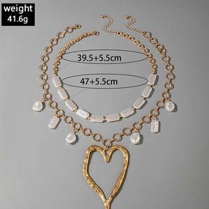 Detail view of double layer gold necklace with heart pendant and faux pearls and dimensions