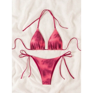 Close-up of pink tie-dye bikini set with lace-up details on white silk background