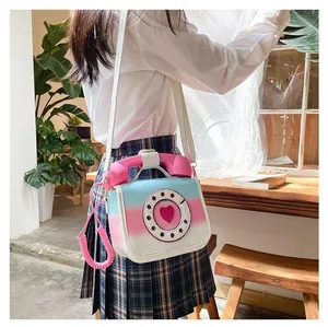 Detail of creative vintage telephone shaped crossbody bag in blue and pink gradient PU