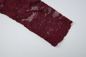 Primo piano dettagliato della trama in pizzo bordeaux e del ricamo sulla maglia attillata