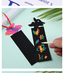 Close-up of hand using a wooden stylus on DIY animal scratch paper bookmarks with ribbons