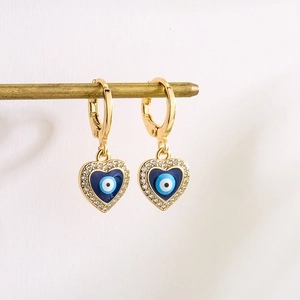 Gold hoop earrings featuring heart-shaped evil eye pendants with blue enamel and rhinestones