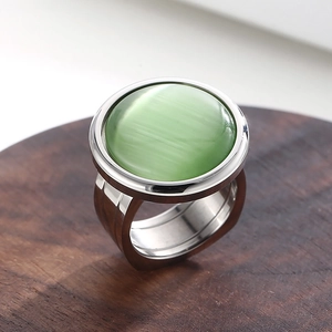 Close-up of a large green round cat eye stone set in a polished silver steel band