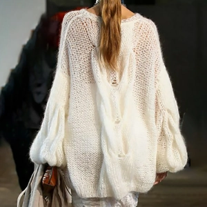 Detailed view of oversized white cable knit sweater with cozy mohair texture