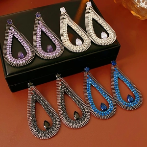 Detailed view of teardrop hollow earrings in purple silver black and blue zircon
