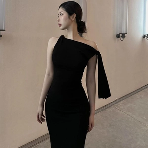 Detail of elegant black one-shoulder dress showing slim fit cut and premium fabric texture