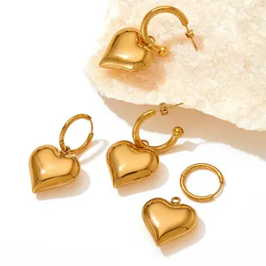 3D gold heart hoop earrings with vacuum plating on white stone textured backdrop