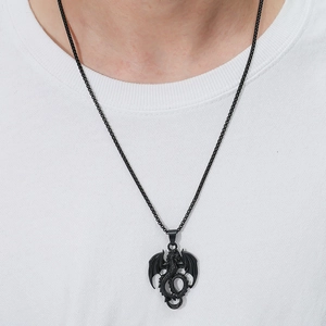 Close-up of a black dragon pendant on a round box chain worn by a male model