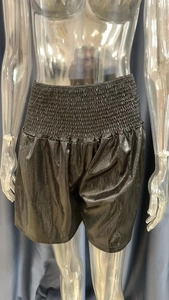 Close-up of black metallic coated shorts with elastic waistband on a mannequin