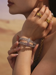 Detail of silver chain bracelets with sparkling crystals and gold rings on model