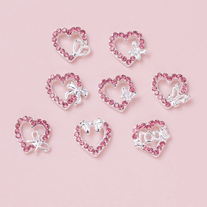 Close-up of 8pcs pink heart and bow nail art charms with silver alloy and rhinestones