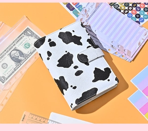 Detail view of A6 cow print budget binder with 6-ring clips and transparent zipper bags