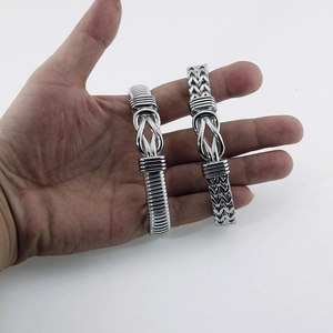 Detail of silver men's stainless steel punk bracelets with intricate woven patterns