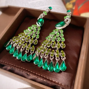 Vintage peacock tassel earrings with green crystals and silver needles on velvet box