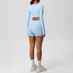 Detail of light blue yoga set featuring a long sleeve crop top and high waist shorts