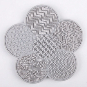 Macro view of flower-shaped silicone makeup brush cleaning mat with varied textures