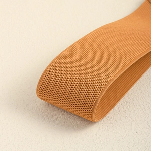 Macro shot of high-elasticity woven belt in camel brown showing thick textured fabric