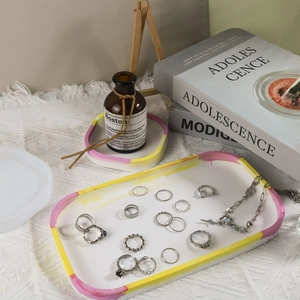 Close-up of oval resin tray with jewelry and watercolor marble texture detail