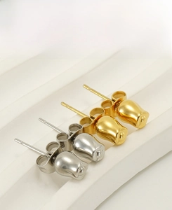 Detailed view of 3D rose bud stud earrings in polished gold and silver finishes