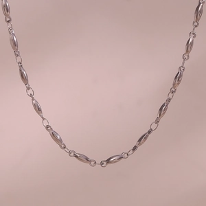 Close-up of minimalist silver stainless steel necklace with olive-shaped chain links