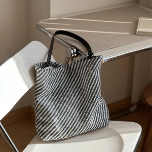 Detail of tweed tote bag texture with black and white stripes and colorful specks