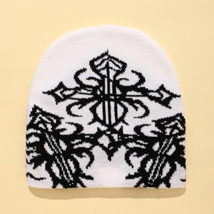 White knitted beanie featuring a black gothic cross pattern and ribbed texture detail