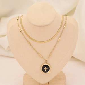 Détail d'un collier à double chaîne dorée avec pendentif croix sur un mannequin de cou