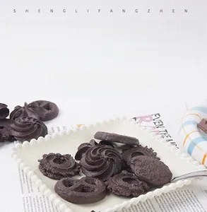 Detailed macro view of chocolate cookie models in various shapes on a white tray