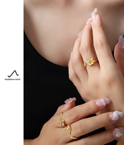 Detail of two creative fox-style stainless steel gold rings worn on a model's hand