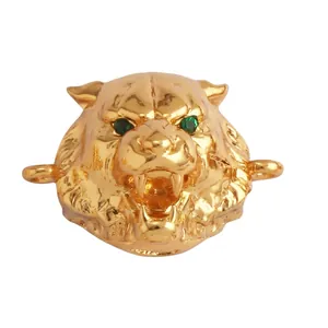 Macro detail of 18k gold plated tiger head connector with green zircon eyes and fine texture
