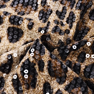 Macro view of leopard print fabric with shimmering sequins and intricate beaded details