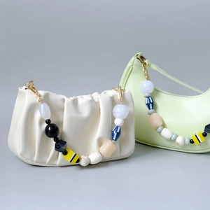 Fashionable off-white and green leather bags with colorful beaded chain straps