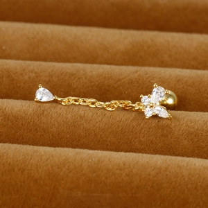 Vue macro de la boucle d'oreille dorée avec papillon, zircon goutte et chaîne
