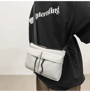 Detailed back view of a light gray nylon messenger bag with adjustable black strap