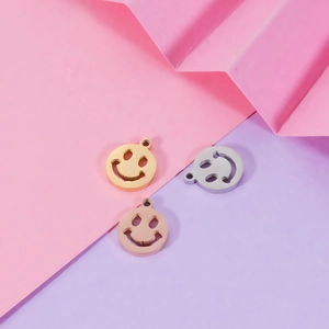 Close-up of 9mm hollow smiley face pendants in gold, silver, and rose gold finishes