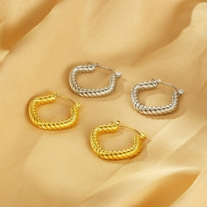Vintage 18K gold and silver plated geometric twisted hoop earrings on silk background