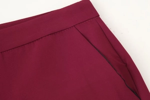 Dettaglio dei pantaloni bordeaux con tasche laterali funzionali e cuciture precise