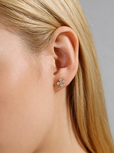 Detail shot of flower stud earring with pear-cut zirconias on model's ear