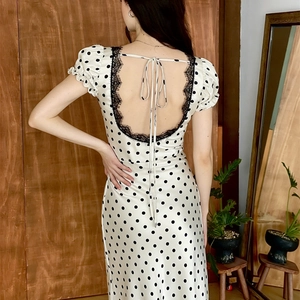 Dettaglio dell'abito a pois con patchwork di pizzo e lacci sul retro su tessuto morbido