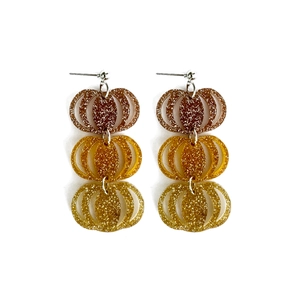 Detailed view of pumpkin-shaped acrylic earrings with orange glitter gradient design