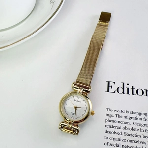 Elegant gold vintage women's quartz watch with mesh strap and crystal-set dial on magazine