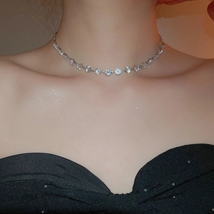 Close-up of a silver tennis necklace with sparkling round zircon stones on a model