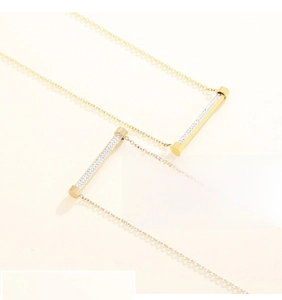 Vue détaillée des pendentifs cylindriques en or et or rose sertis de micro-pavés de zircons
