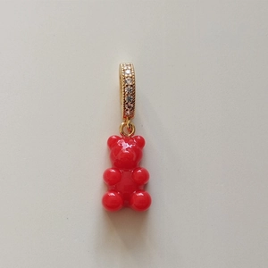 Close-up of a red resin gummy bear pendant with a gold-plated zircon studded clasp