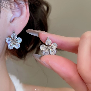 Detailed view of cubic zirconia flower earrings worn by a model with shiny crystals