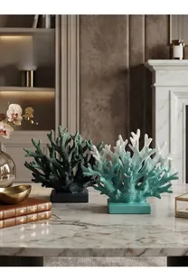 Detail of coral resin sculptures with organic texture on a modern marble tabletop