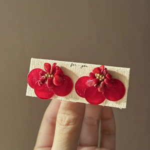 Elegant red flower earrings featuring translucent petals and golden bead accents