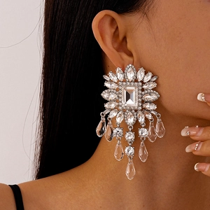 Macro detail of luxury floral rhinestone tassel earrings worn on a model for gala events